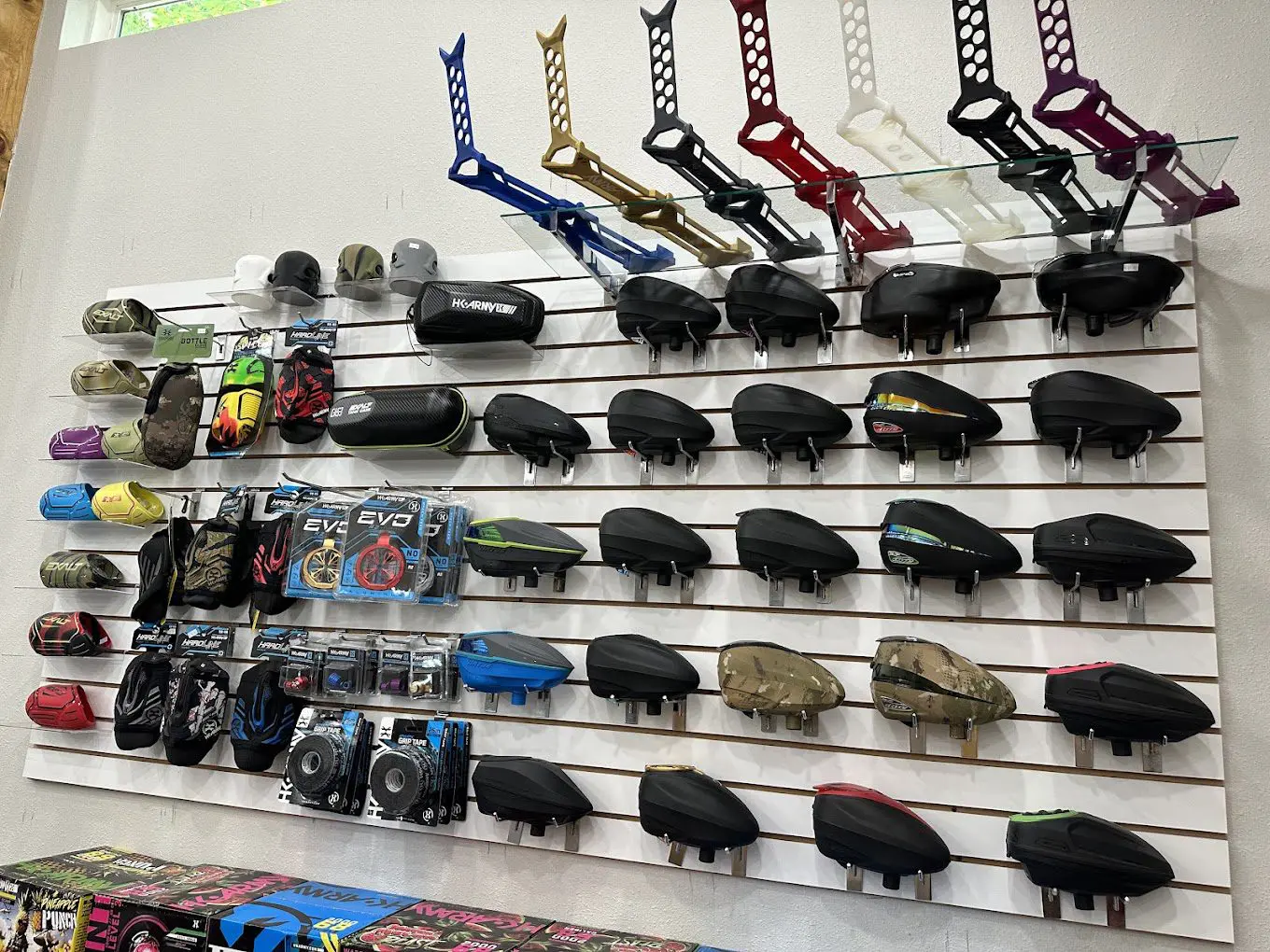 A wall of toy cars and helmets on display.