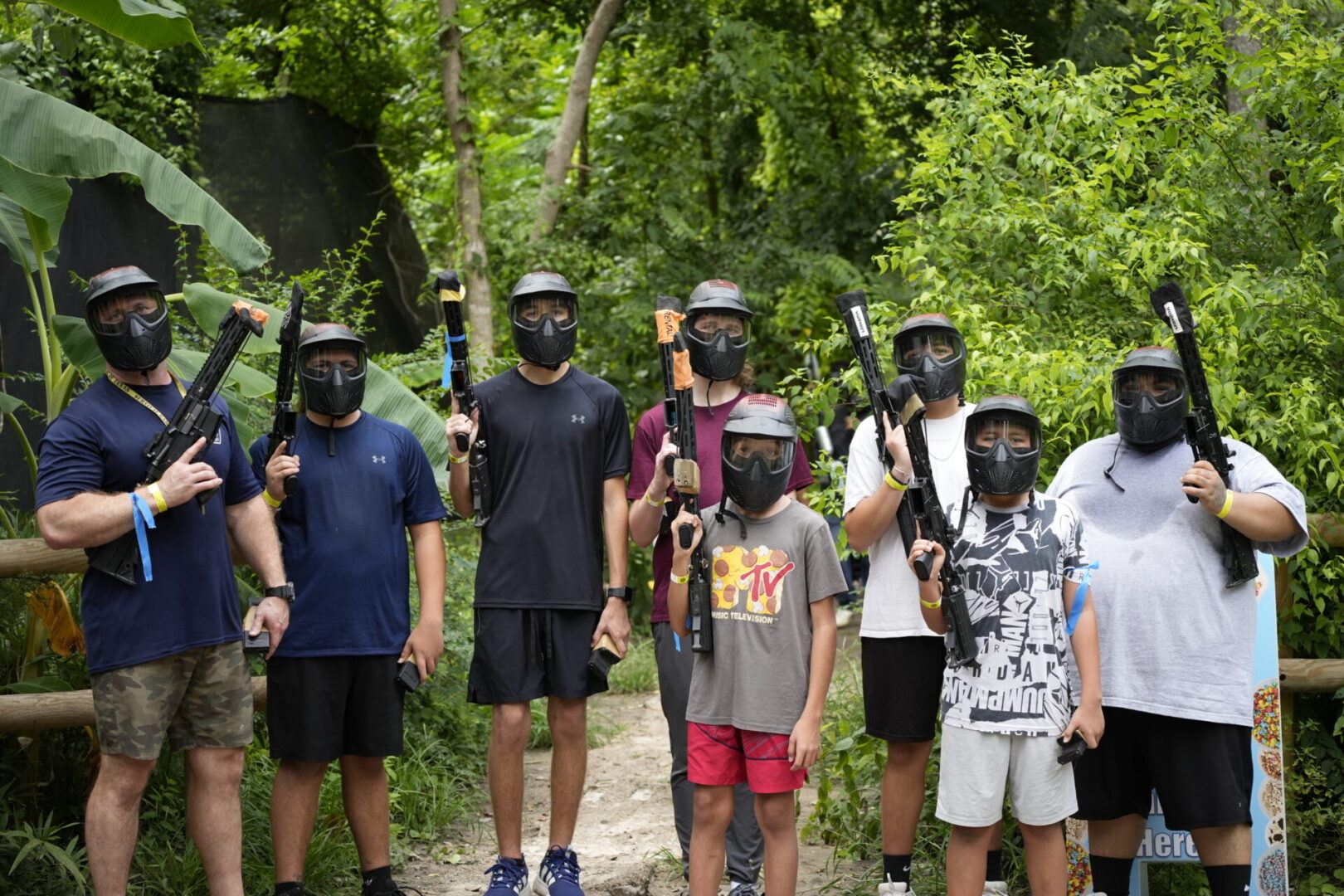 Group playing paintball in a forest setting.