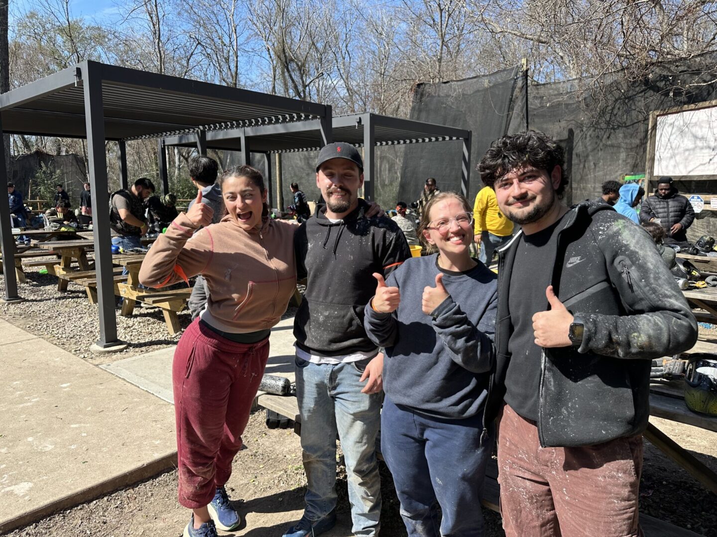 A group of friends smiling and giving thumbs up together before heading out to the playing fields.